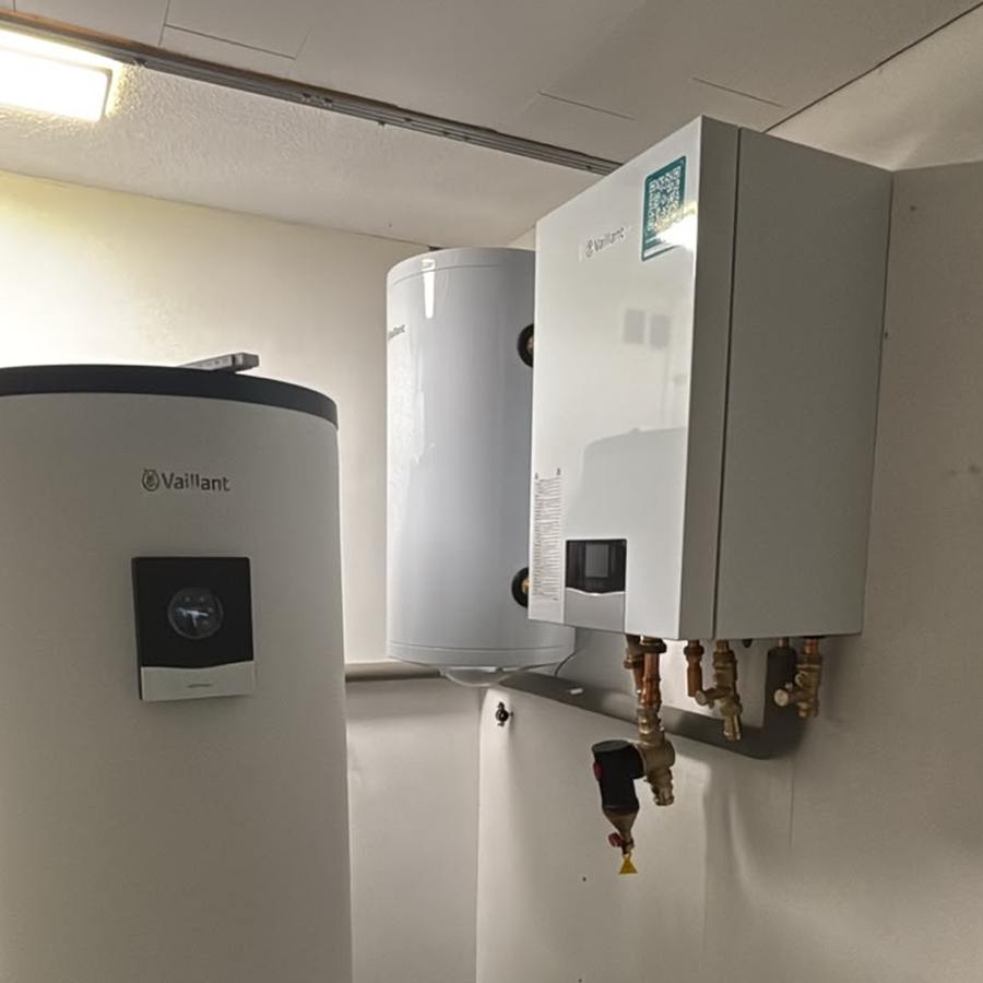 Technikraum im Obergeschoss mit Vaillant-Innengerät an der Wand, Speicher und verlöteter Hydraulik mit Schmutzabscheider